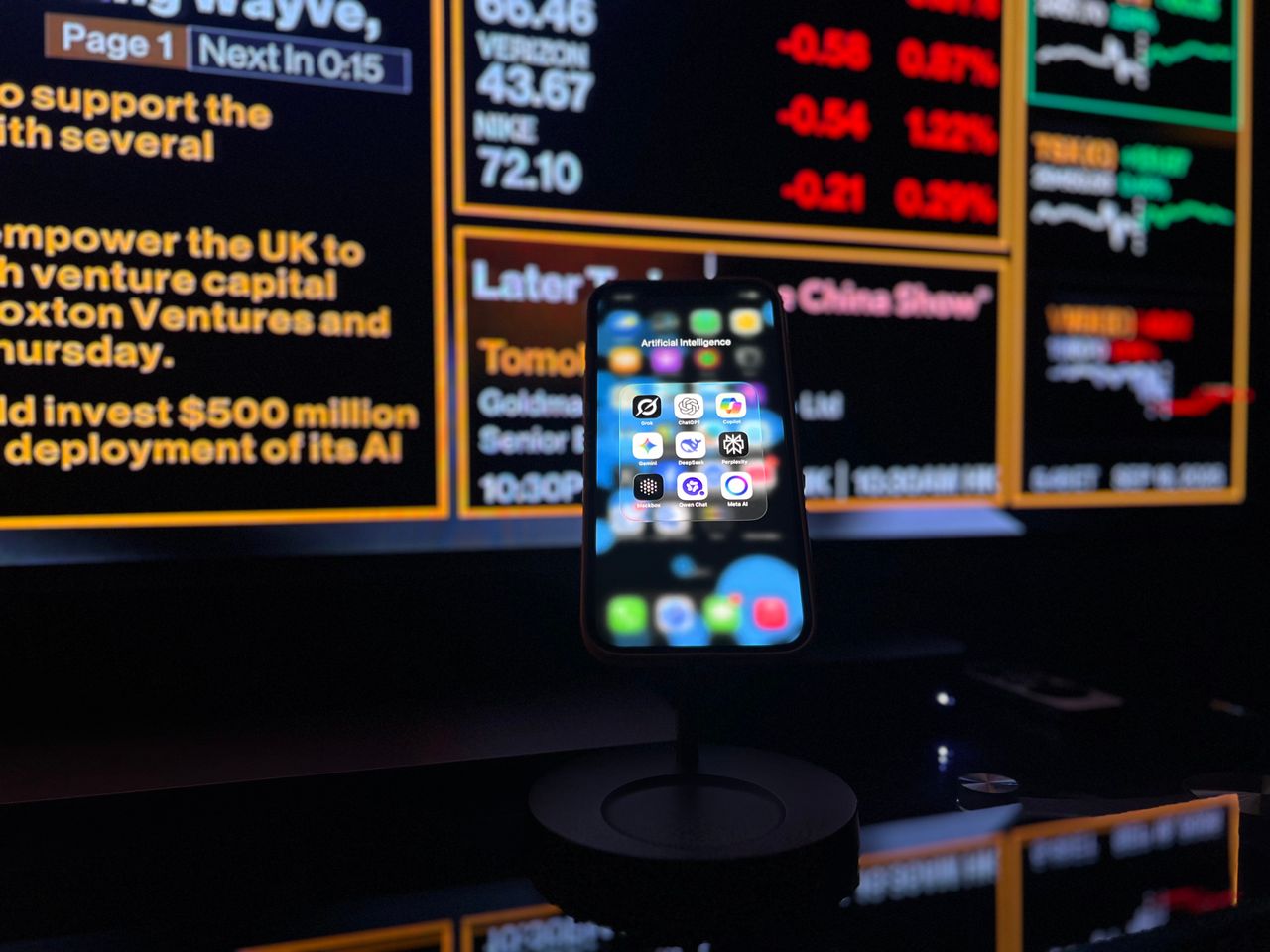 about-02 Smartphone displaying AI apps in front of a financial data screen in London.